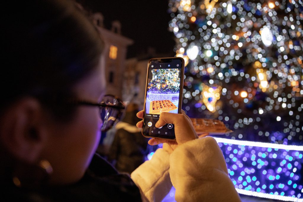 Image of a phone user at a Christmas market - Best-Christmas-social-media-campaigns-Copify-blog-3-1024x683
