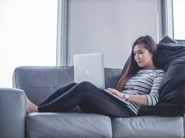 Woman using laptop on sofa - Content-writing-courses-2021-Copify-blog-1-740x555-1