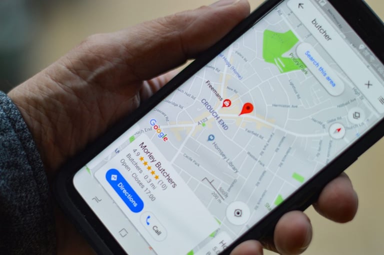 Person holding a phone with a local service ad on a map - How does advertising increase brand awareness - Copify blog