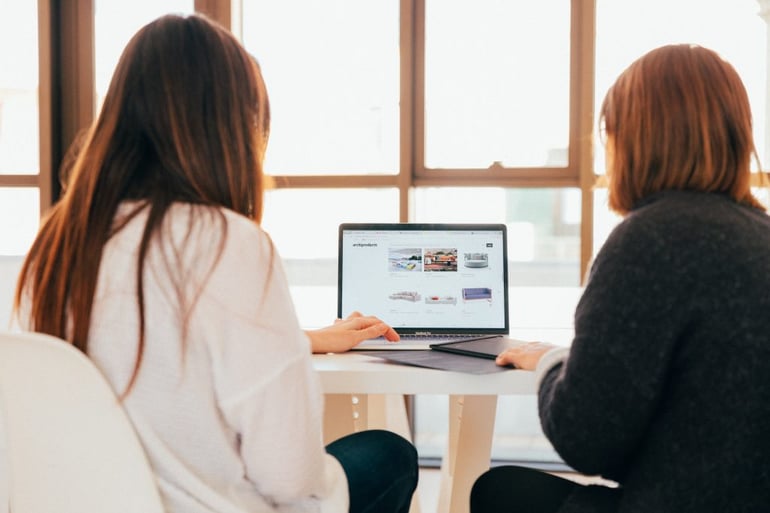 Image of two women looking at a computer screen - How much does a content marketing consultant cost - Copify blog
