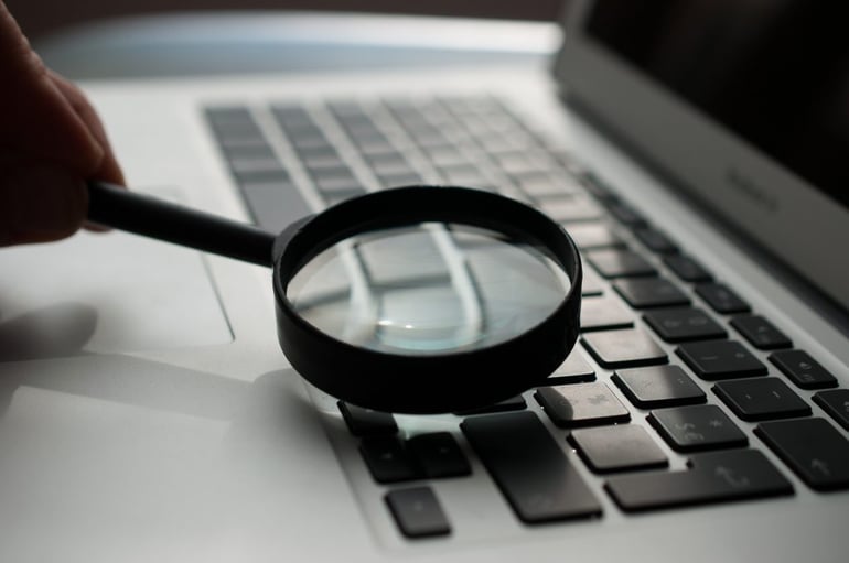 Magnifying glass on laptop keyboard - How to check unique content online free - Copify blog 1