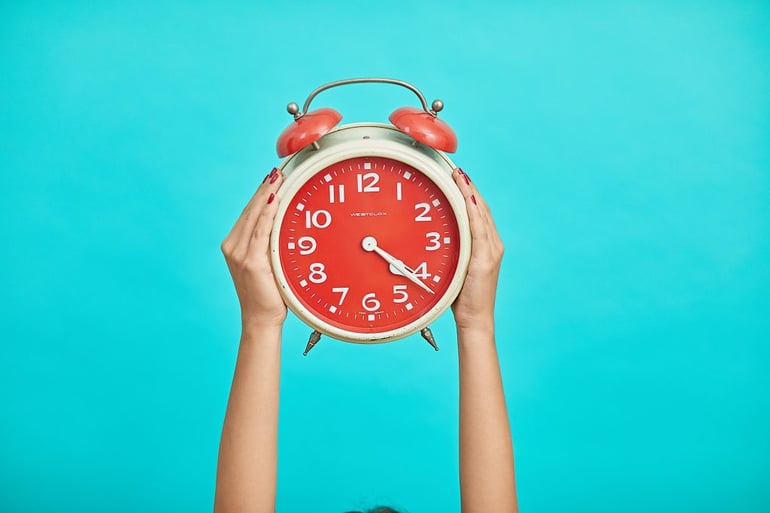 Hands holding alarm clock - The importance of body copy in advertising - Copify blog