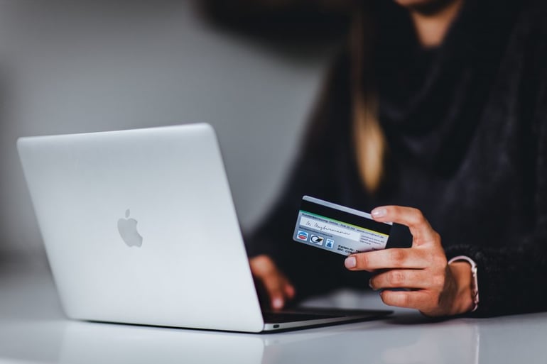 Image of someone paying with a credit card on a laptop - What is a content matrix - Copify blog
