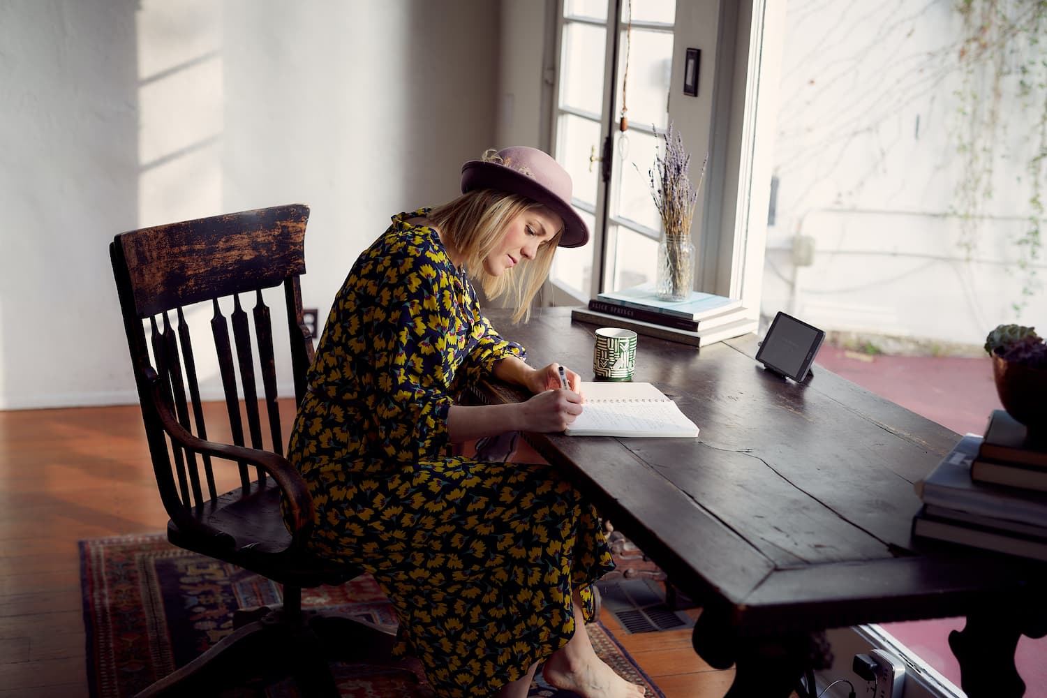 Woman writing at desk - 10 best blogs for writers - Copify Blog
