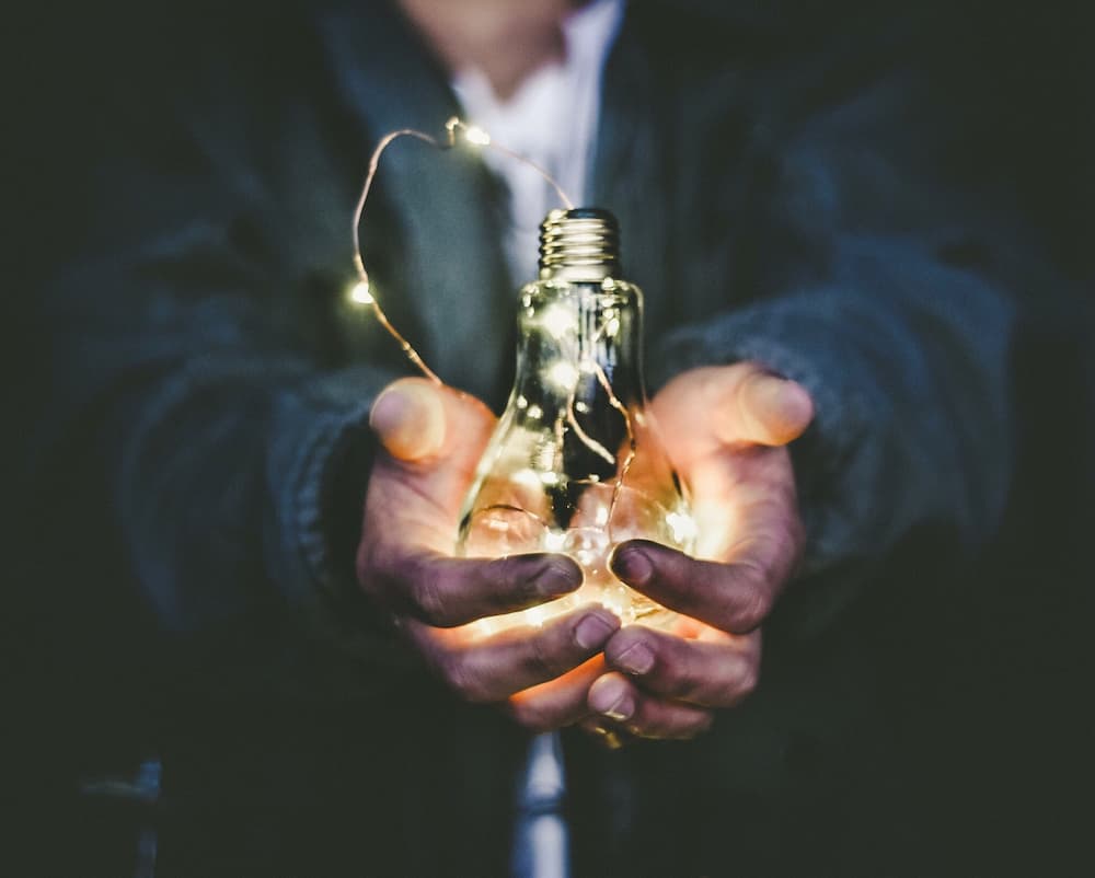 Man holding lightbulb - 10 best content writing tools - Copify blog