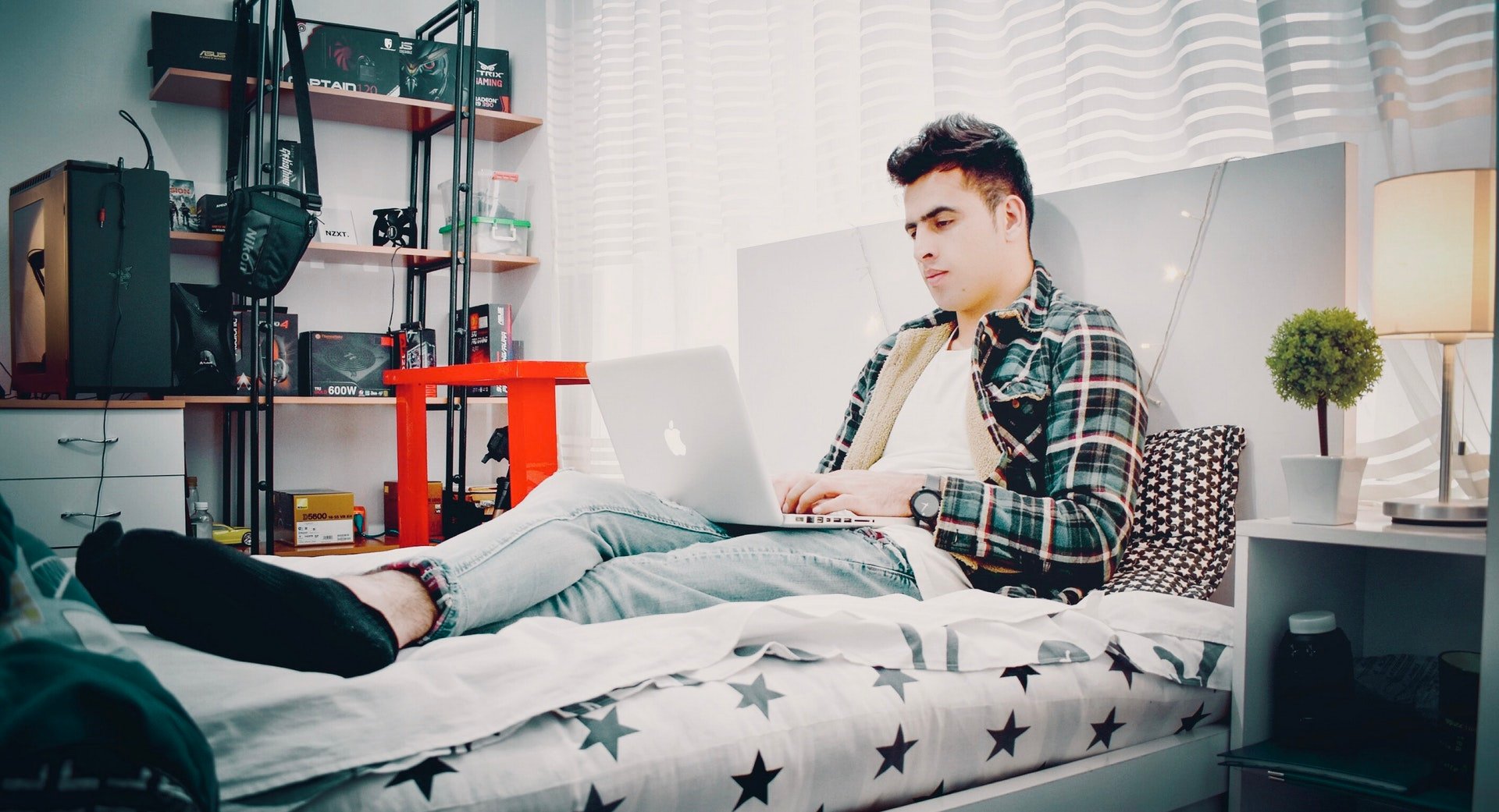 Young man on laptop on bed