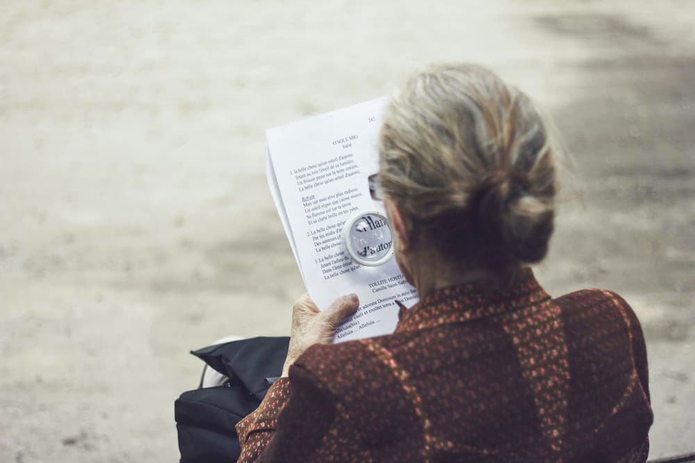 Woman with magnifying glass - How to check copied content online - Copify blog