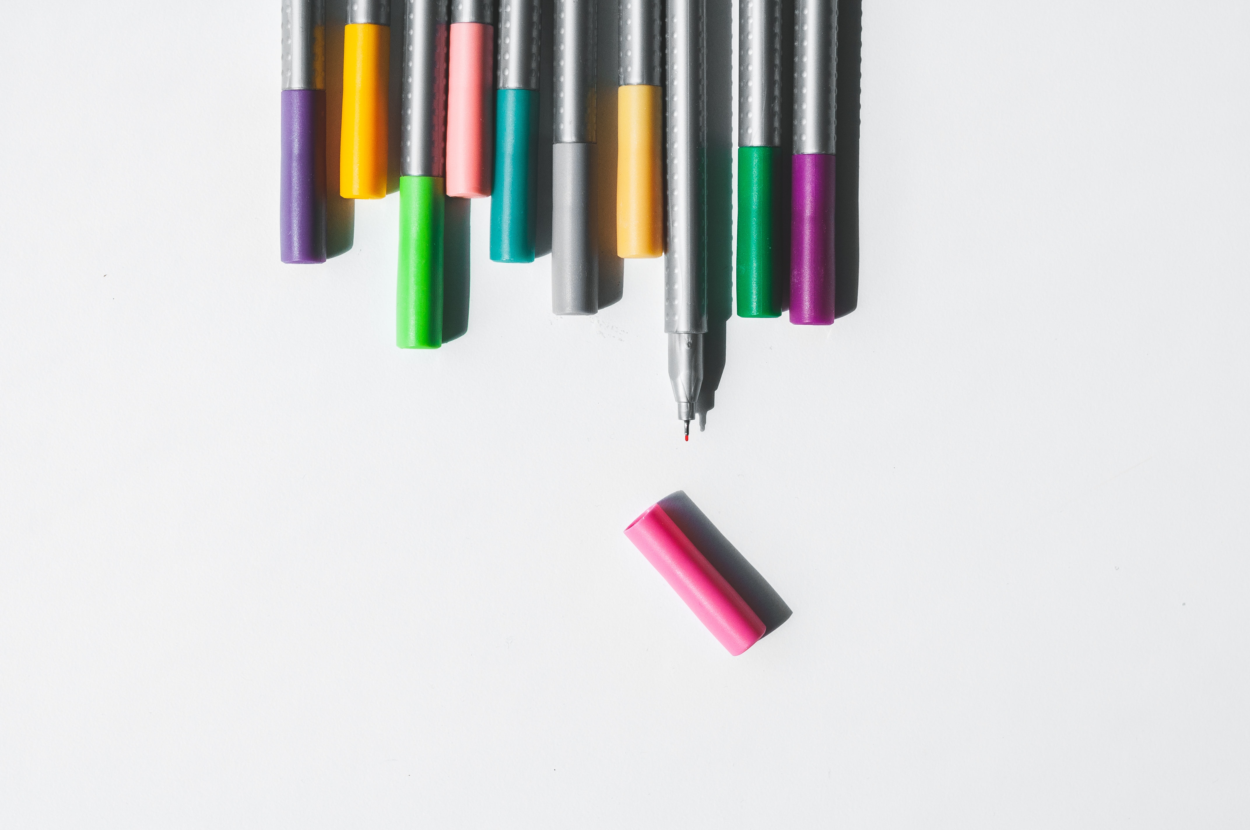 Coloured pens with one lid off