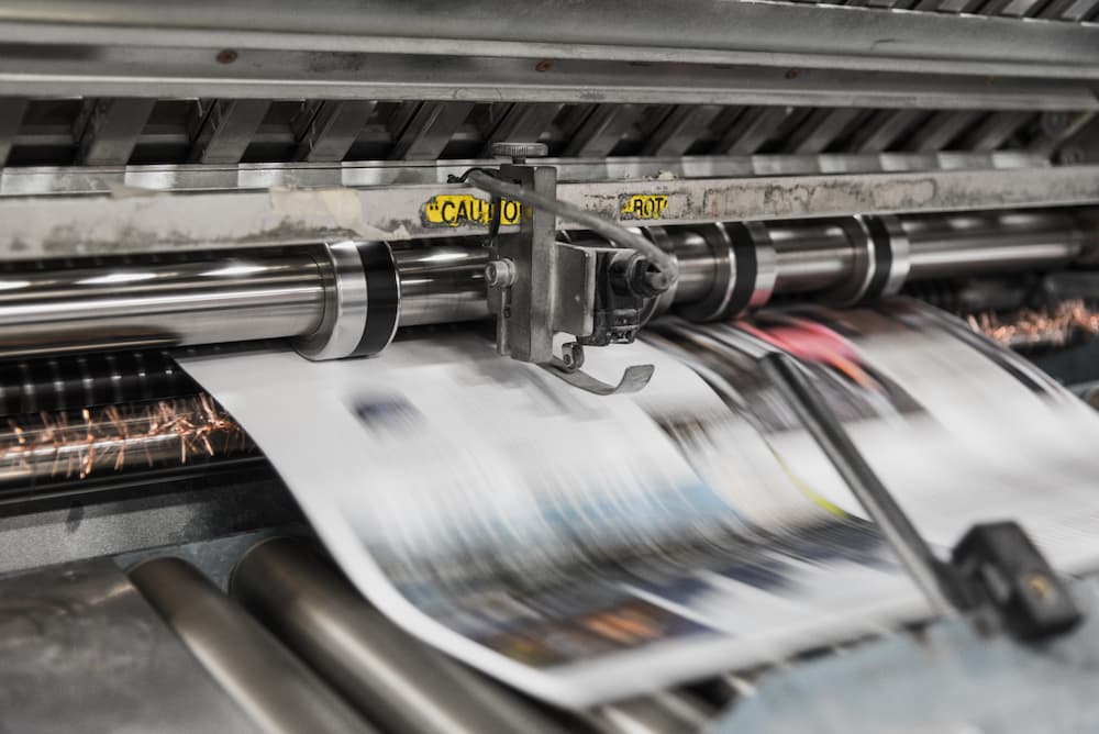 Image of a newspaper being printer - How to create a killer press release template - Copify blog