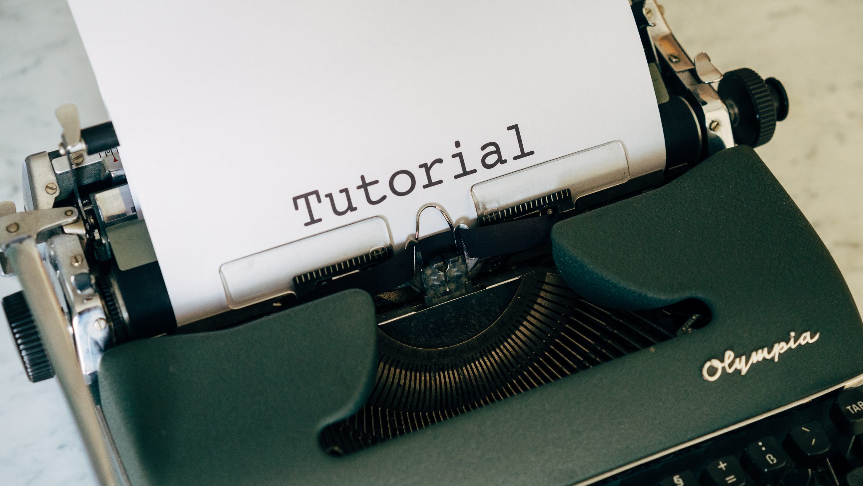 Typewriter with 'tutorial' spelled out - Blog article writing tutorial for beginners - Copify blog