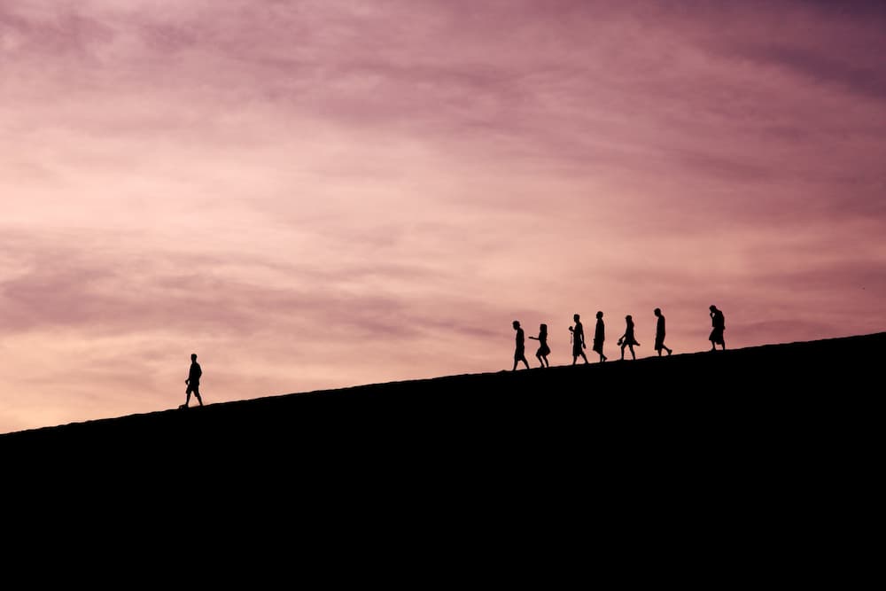 Image of people following man down a hillside - The top 10 copywriting experts you need to follow - Copify blog