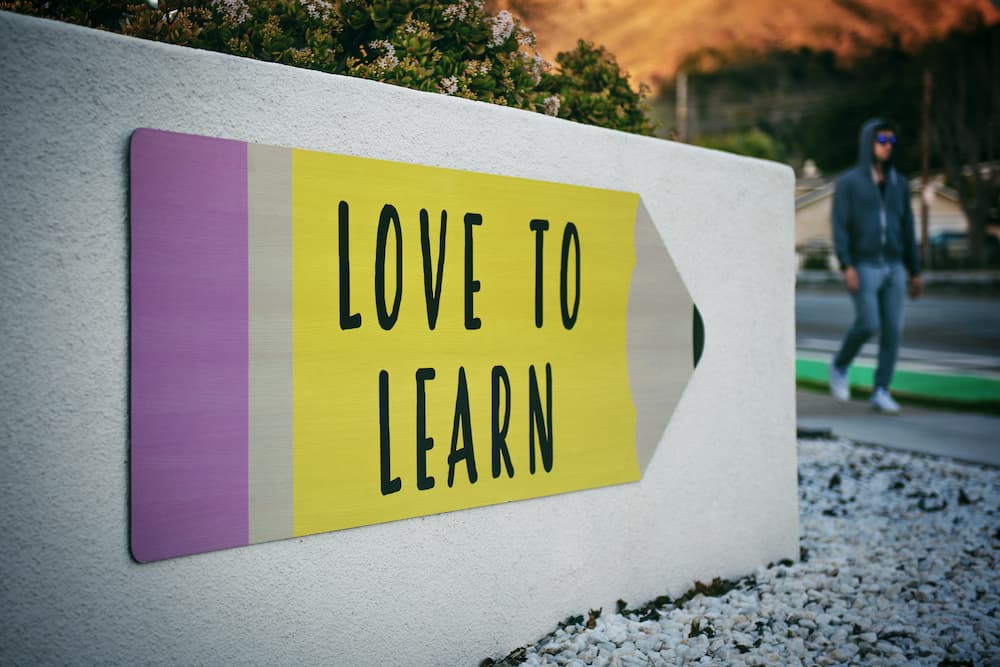 Sign saying 'love to learn' - Top 7 content writing courses - Copify blog