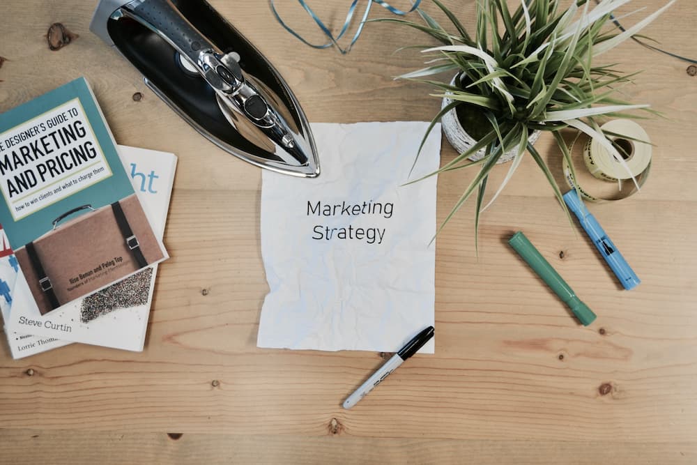 Desk with pens and the front cover of a page which says 'marketing strategy' - What is a content matrix - Copify blog