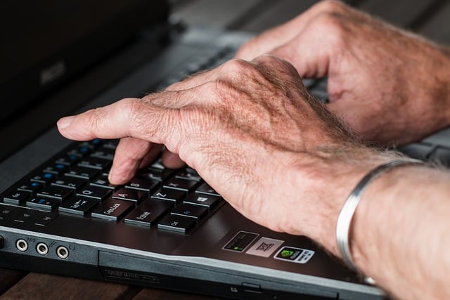 Man typing on laptop keyboard - What's the difference between a content writer and technical writer - Copify Blog