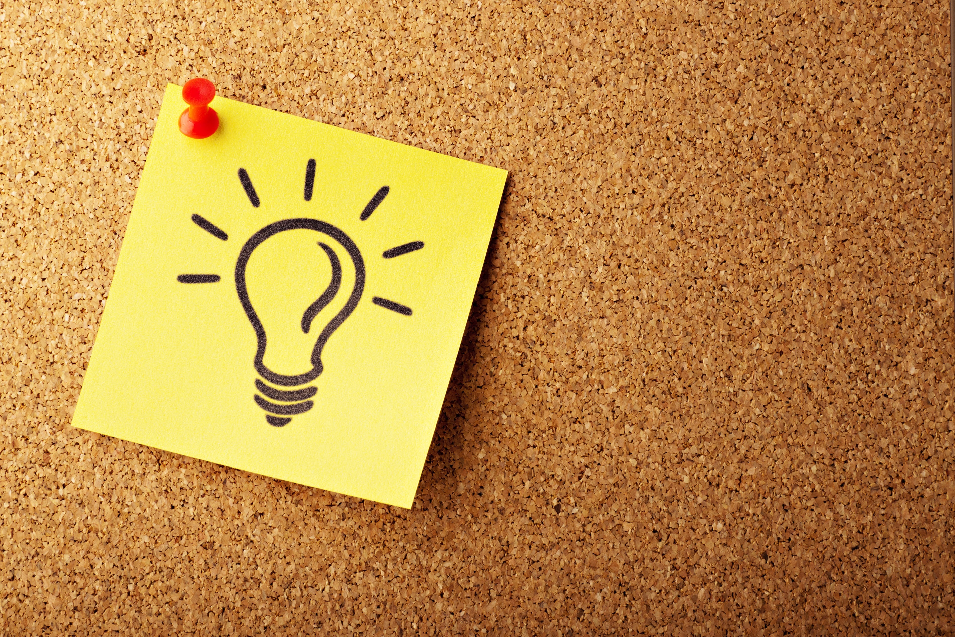 Post-it note with lightbulb on corkboard - 5 fantastic content marketing idea generators - Copify Blog